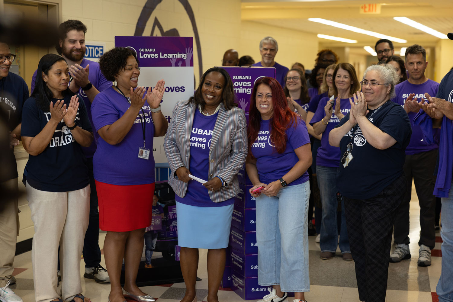 A diverse group of people, mostly wearing purple