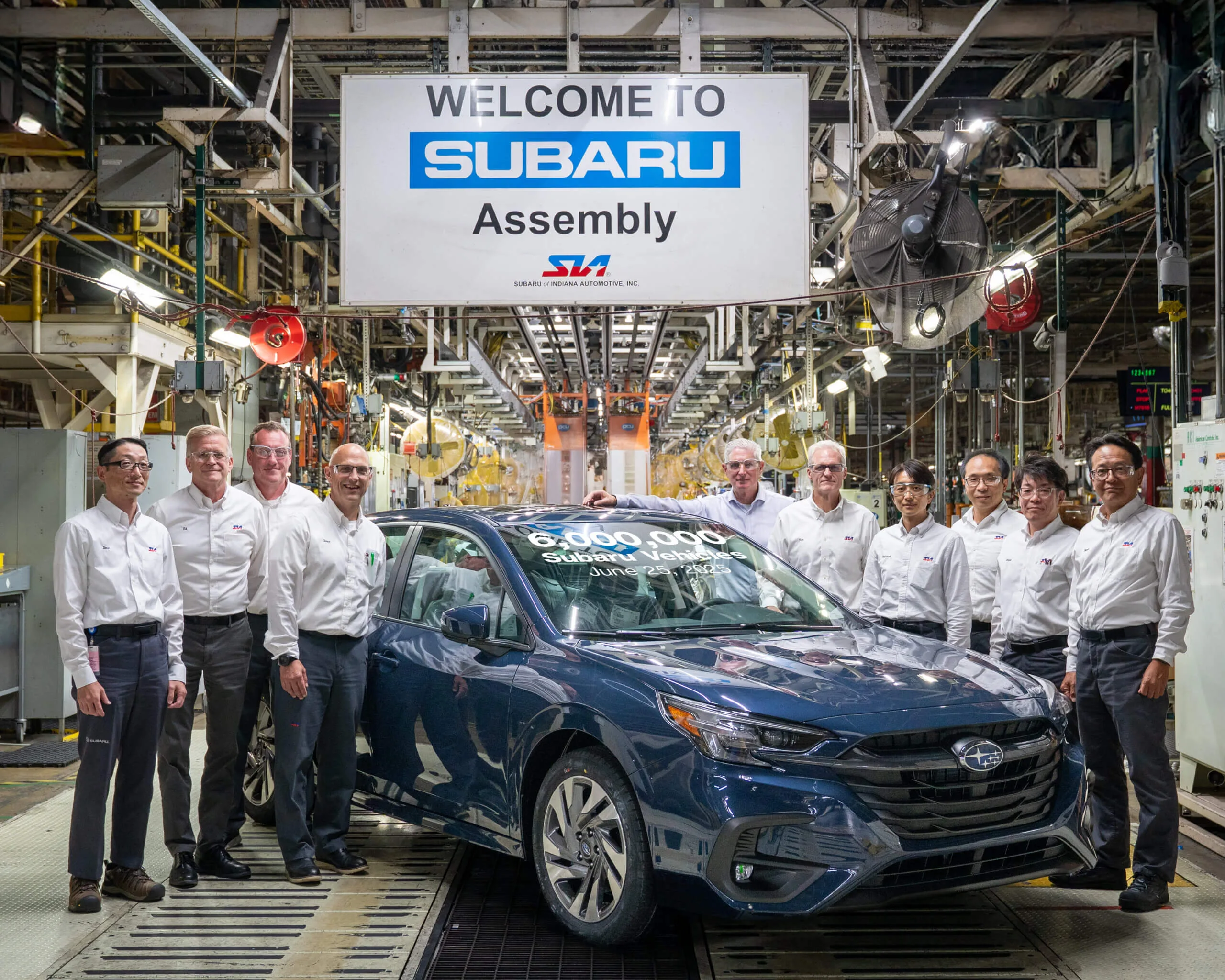 SIA representatives standing with a Subaru vehicle celebrating six million Subaru vehicles produced.