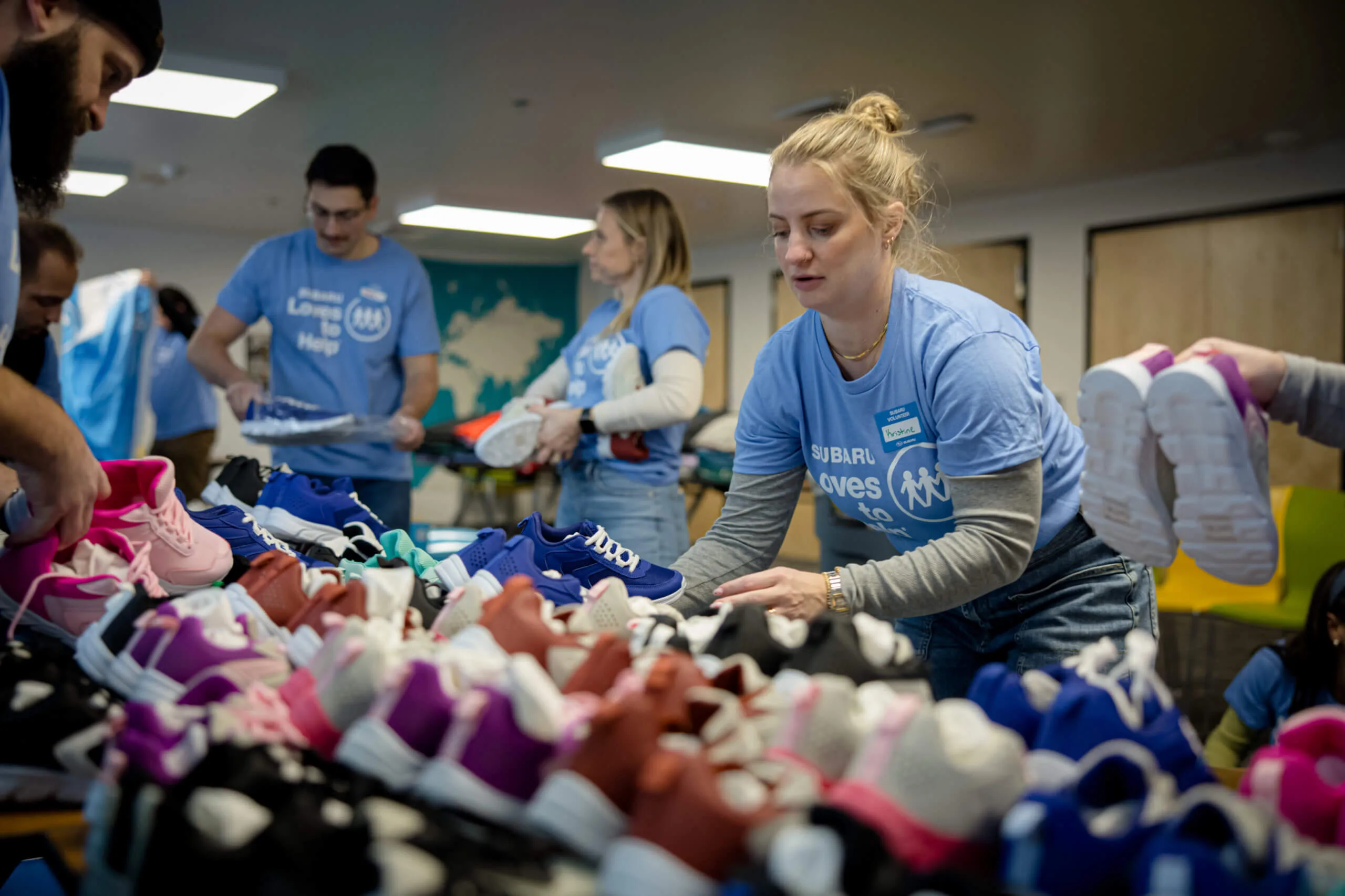 Subaru volunteers sorting shoes during a Subaru Loves to Help event.