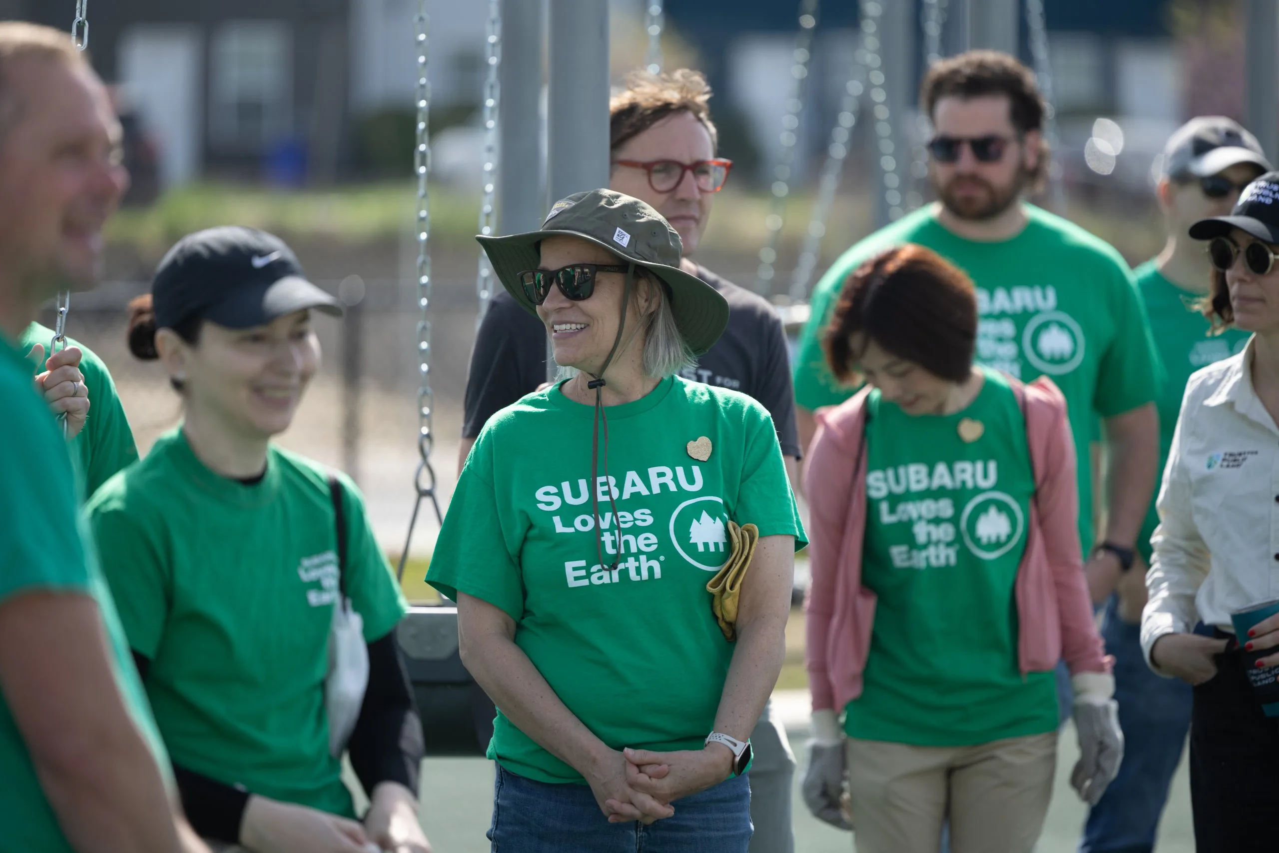 Group of Subaru employees in green Subaru Loves the Earth shirts at an outdoor volunteer event