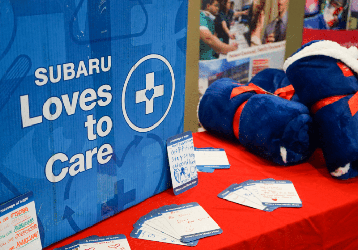 Subarue Loves to Care LLS donation table with cards and blankets
